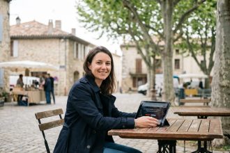 Femme souriante au café dans un village de Castelnaudary